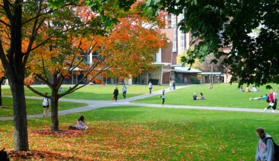 Students walking and sitting on Skidmore College Quad in the Fall