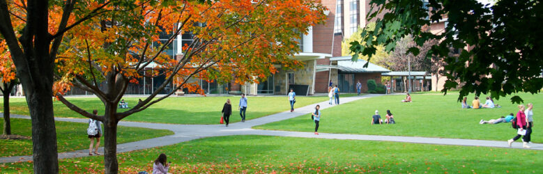 Students walking and sitting on Skidmore College Quad in the Fall