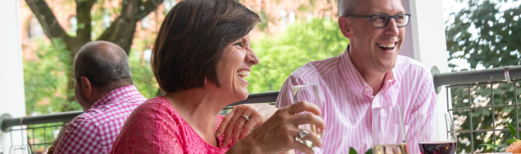 Couple having drinks on the porch of Saratoga Arms Hotel