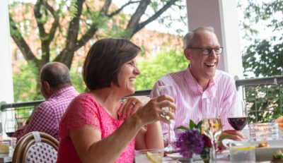 Couple having drinks on the porch of Saratoga Arms Hotel